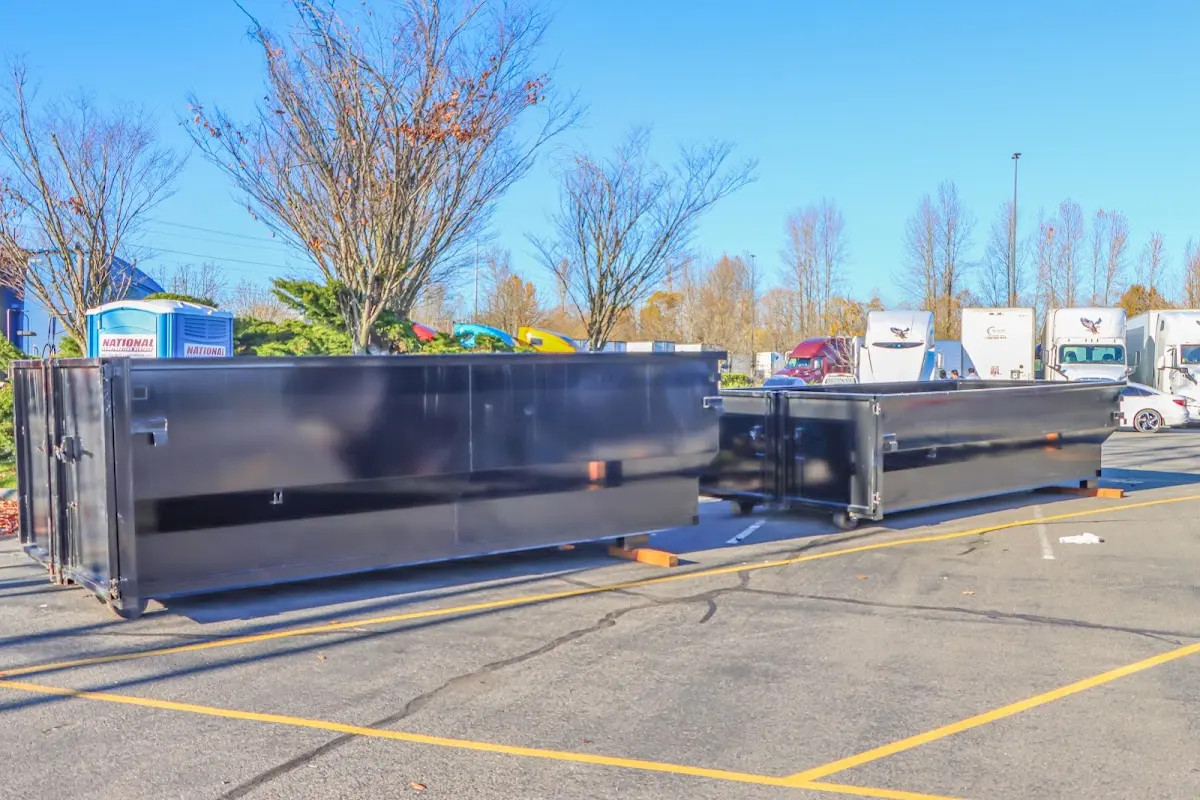 Professional dumpster rental service with roll-off container on residential driveway in Wollochet